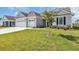 Charming single-story home with manicured lawn, featuring a three-car garage, and a young tree in the yard at 1121 Oxeye St., North Myrtle Beach, SC 29582