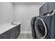 Laundry room with front loading washer and dryer, sink and dark gray cabinets at 1121 Oxeye St., North Myrtle Beach, SC 29582