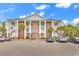 Spacious condominium with brick and white facade with palm trees and ample parking at 118 Birch N Coppice Dr. # 2, Surfside Beach, SC 29575