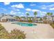 Community pool area with lounge chairs, palm trees, and condominium buildings in the background at 118 Birch N Coppice Dr. # 2, Surfside Beach, SC 29575