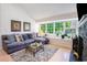 Bright living room with large windows, a gray sectional, and a decorative fireplace with mantle at 1205 Erin Way # 5C, Myrtle Beach, SC 29577