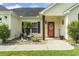 Inviting covered front porch with an orange front door, complemented by a well-maintained landscaped garden at 131 River Country Dr., Conway, SC 29526