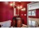 Bathroom with a vanity and elegant faucet and a large mirror, featuring dark red walls at 1473 Basin Trail, Murrells Inlet, SC 29576