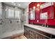 Elegant bathroom with a double sink vanity, marble shower, and stylish fixtures and bright red walls at 1473 Basin Trail, Murrells Inlet, SC 29576