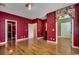 Spacious room with hardwood floors and multiple doorways with red floral wallpaper at 1473 Basin Trail, Murrells Inlet, SC 29576