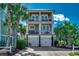 Stunning beachfront home featuring double balconies and a two-car garage nestled among lush palm trees at 1473 Basin Trail, Murrells Inlet, SC 29576