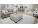 Open-concept living room showcases a gray sofa, ottoman, and connects to the kitchen and dining area at 1664 Hope Pointe Dr, North Myrtle Beach, SC 29582