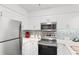 Bright kitchen featuring white cabinets, stainless steel appliances, and tiled backsplash at 180 Rothbury Circle # 305, Myrtle Beach, SC 29572