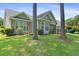 The backyard features mature trees, lush grass, and a screened in porch at 183 Glenwood Dr., Conway, SC 29526