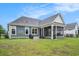 Charming home exterior with screened porch, grill, and lush green lawn under a bright blue sky at 1844 Wood Stork Dr., Conway, SC 29526