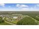 Aerial view of home in a quiet neighborhood surrounded by lush greenery and a pond at 195 Black Pepper Loop, Little River, SC 29566