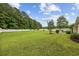 Expansive backyard with a well-manicured lawn, mature trees, and a white picket fence at 195 Black Pepper Loop, Little River, SC 29566
