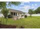 Charming backyard with patio, rocking chairs, grill, and views of the home's exterior at 195 Black Pepper Loop, Little River, SC 29566