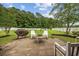 Relaxing backyard featuring a patio, fire pit, Adirondack chairs, and a lush lawn with a white picket fence at 195 Black Pepper Loop, Little River, SC 29566