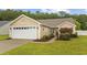 A well-kept single-story home featuring a garage, manicured lawn, and lush green surroundings at 195 Black Pepper Loop, Little River, SC 29566