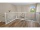 Upstairs hallway with railing, wood-look floors and arched window with view at 1984 Green Fern Ln. # 1984, Myrtle Beach, SC 29579