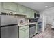 Modern kitchen showcasing stainless steel appliances, stylish backsplash, and green cabinets for a fresh look at 2001 S Ocean Blvd. # 1405, Myrtle Beach, SC 29577