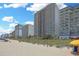 View of oceanfront condominiums with beach access, sandy shores, and clear blue sky at 2007 S Ocean Blvd. # 1403, Myrtle Beach, SC 29577