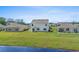 Back exterior of house with a spacious yard, patio, and views of neighboring homes at 2106 Ainsley Dr., Little River, SC 29566