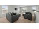 Living room featuring two gray sofas, a television, neutral walls, and two windows at 2106 Ainsley Dr., Little River, SC 29566