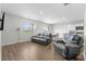 Open living room with hardwood floors, leather sofas, and a view of the dining area and kitchen at 2106 Ainsley Dr., Little River, SC 29566