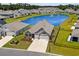 Aerial view of a home in a serene neighborhood with a scenic pond, lush greenery, and well-maintained landscaping at 215 Kendrick St., Little River, SC 29566