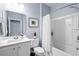 Bright bathroom showcasing a tub with shower, a white vanity with a large mirror, and modern fixtures at 215 Kendrick St., Little River, SC 29566