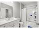 Bright bathroom featuring a tub with shower, a white vanity with a large mirror, and tile floors at 215 Kendrick St., Little River, SC 29566