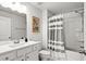 Clean bathroom with a gray and white striped shower curtain, vanity, sink, and modern fixtures at 215 Kendrick St., Little River, SC 29566