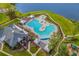 Aerial view showcases the community pool with ample seating, a hot tub, and well-manicured landscaping at 215 Kendrick St., Little River, SC 29566
