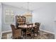 Bright dining room featuring a wooden table, wicker chairs, and stylish chandelier, illuminated by natural light from shuttered windows at 215 Kendrick St., Little River, SC 29566