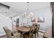 An airy dining room with a round wood table, complemented by elegant decor and views into the modern kitchen and staircase at 215 Kendrick St., Little River, SC 29566