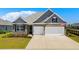 Attractive exterior showcasing a well-maintained lawn, brick accents, and a spacious two-car garage enhancing the home's curb appeal at 215 Kendrick St., Little River, SC 29566