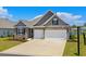 Beautiful home exterior featuring a large driveway, two-car garage, and lush landscaping, offering an inviting and welcoming curb appeal at 215 Kendrick St., Little River, SC 29566