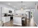 Well-lit kitchen featuring white cabinets, a kitchen island with seating, and stainless steel appliances for a stylish and functional space at 215 Kendrick St., Little River, SC 29566