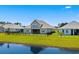 A nicely manicured backyard with black fence bordering a lake and a view of the home's screened porch at 215 Kendrick St., Little River, SC 29566