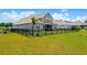 Back of home features manicured lawn, black fence, and a view of the screened porch and palm tree at 215 Kendrick St., Little River, SC 29566