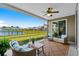 Relaxing screened porch with wicker furniture, ceiling fan, and views of the backyard and scenic lake at 215 Kendrick St., Little River, SC 29566