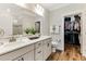 Well-lit bathroom features double sinks, a large mirror, and a spacious closet with organized storage at 215 Vivian St. Nw # 215, Calabash, NC 28467
