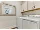 Bright laundry room with modern washer and dryer, white cabinets, and a stylish mirror for added convenience at 215 Vivian St. Nw # 215, Calabash, NC 28467