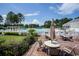 Outdoor patio with comfortable seating, umbrellas, lush landscaping, and pool in the background at 215 Vivian St. Nw # 215, Calabash, NC 28467