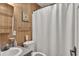 Functional bathroom featuring wood paneling, a shower with curtain, and essential fixtures for daily use at 25 Newport St., Ocean Isle Beach, NC 28469