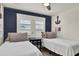 Charming bedroom featuring two twin beds, nautical decor, and ample natural light from window with white shutters at 25 Newport St., Ocean Isle Beach, NC 28469