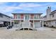 Charming raised beach house with white stairs, a garage, and a waterfront view at 25 Newport St., Ocean Isle Beach, NC 28469