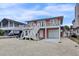Charming raised beach house featuring a two-story design with stairs and a ground-level garage at 25 Newport St., Ocean Isle Beach, NC 28469
