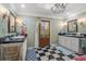 Elegant bathroom with black and white tile, double vanity, granite countertops, and a chandelier at 3907 N Ocean Blvd., Myrtle Beach, SC 29572