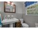 Bathroom featuring a pedestal sink, window, and commode with tile flooring at 3907 N Ocean Blvd., Myrtle Beach, SC 29572