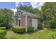 Charming backyard shed with wood siding, white trim, window, and a well-manicured lawn at 3907 N Ocean Blvd., Myrtle Beach, SC 29572