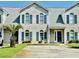 Charming brick townhouse featuring blue shutters, well-maintained landscaping, and a concrete driveway at 3978 Tybre Downs Circle # 3978, Little River, SC 29566