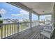 Spacious covered balcony with a view of the community featuring matching white furniture and wooden floors at 421 30Th Ave. S, Sunset Beach, NC 28468